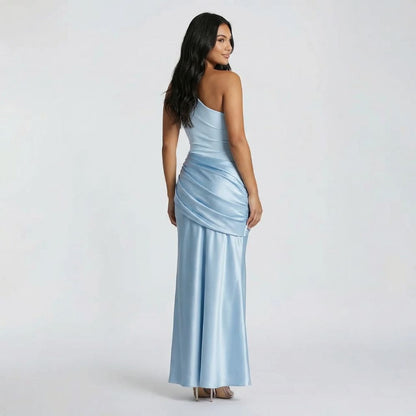 Light blue maxi dress with one-shoulder neckline — back view displaying draped overlay detail and sleek fit.