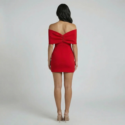 Red off-shoulder bow mini dress — back view highlighting statement bow detail and zip closure.