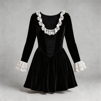 Close-up of black velvet mini dress showing rich texture, lace neckline trim, and ruched bodice design.