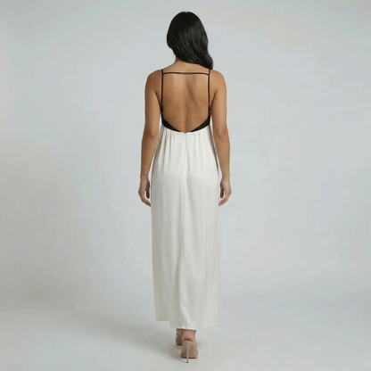 Cream and black colorblock maxi dress — back view displaying low open back design and flowing silhouette.