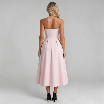 Pink strapless pleated midi dress — back view highlighting pleats and secure zip closure